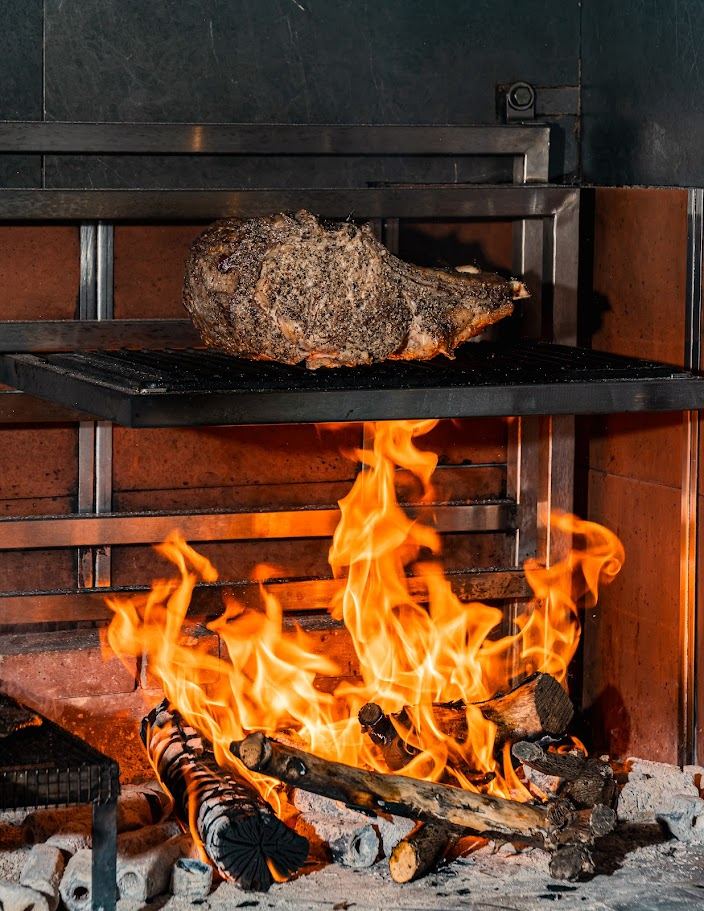 A whole cut of beef over the open wood fire at Salt & Fire
